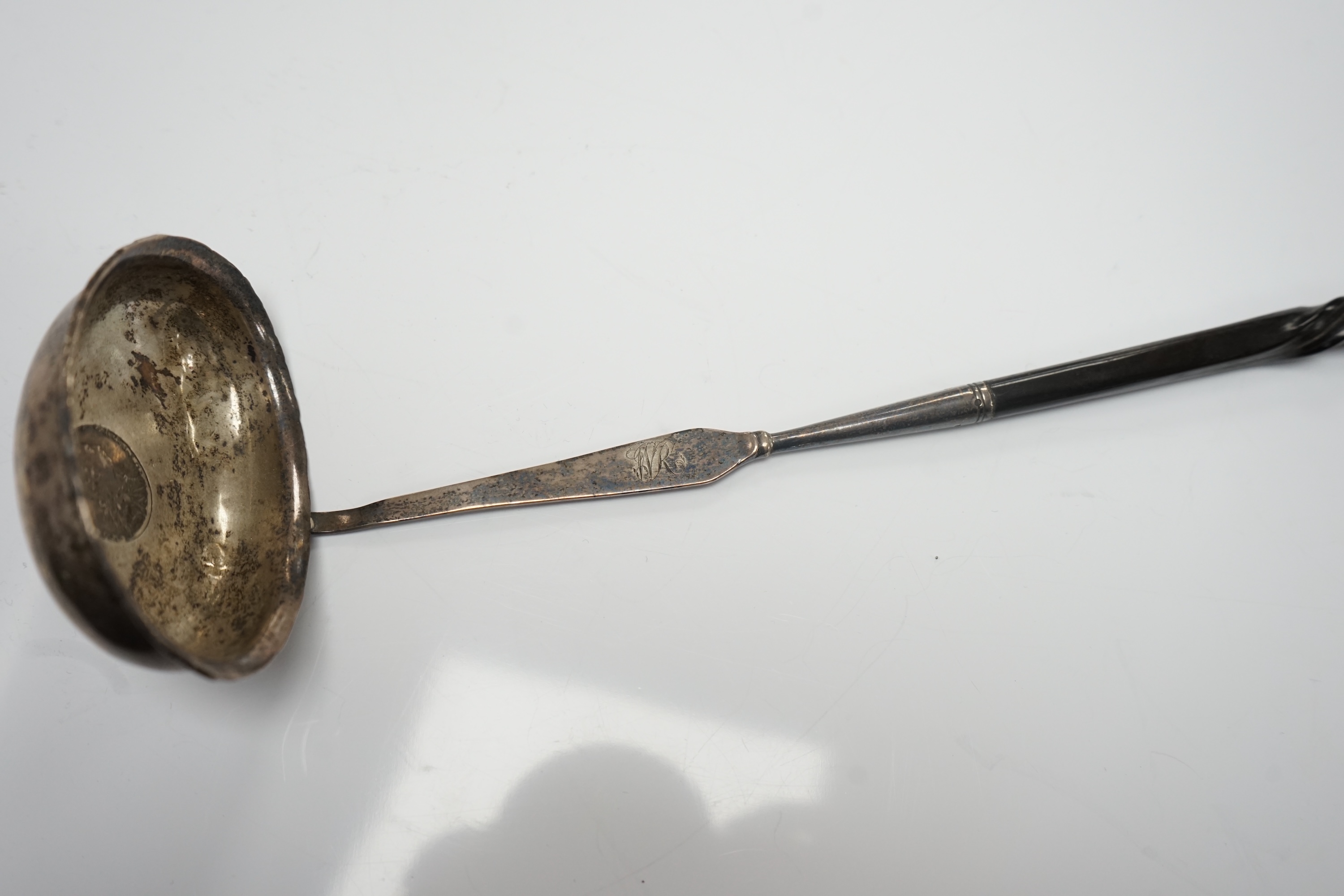 A George III white metal toddy ladle, with baleen handle and inset coin bowl, 38.5cm, unmarked. Condition - poor to fair